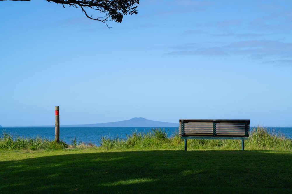 a wooden bench sitting on top of a lush green field