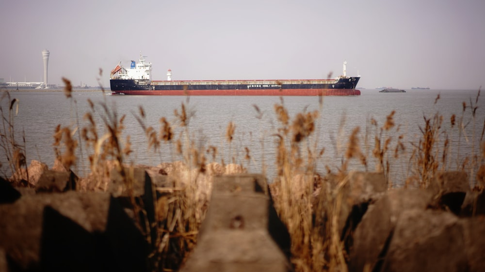 a large cargo ship in the water near some rocks
