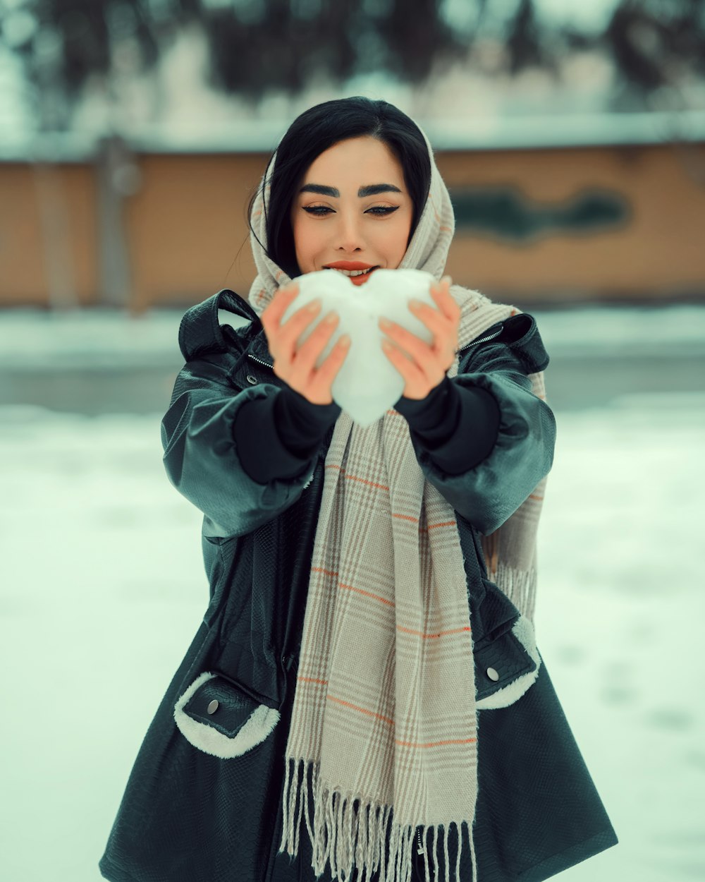 a woman blowing a snowball with her hands