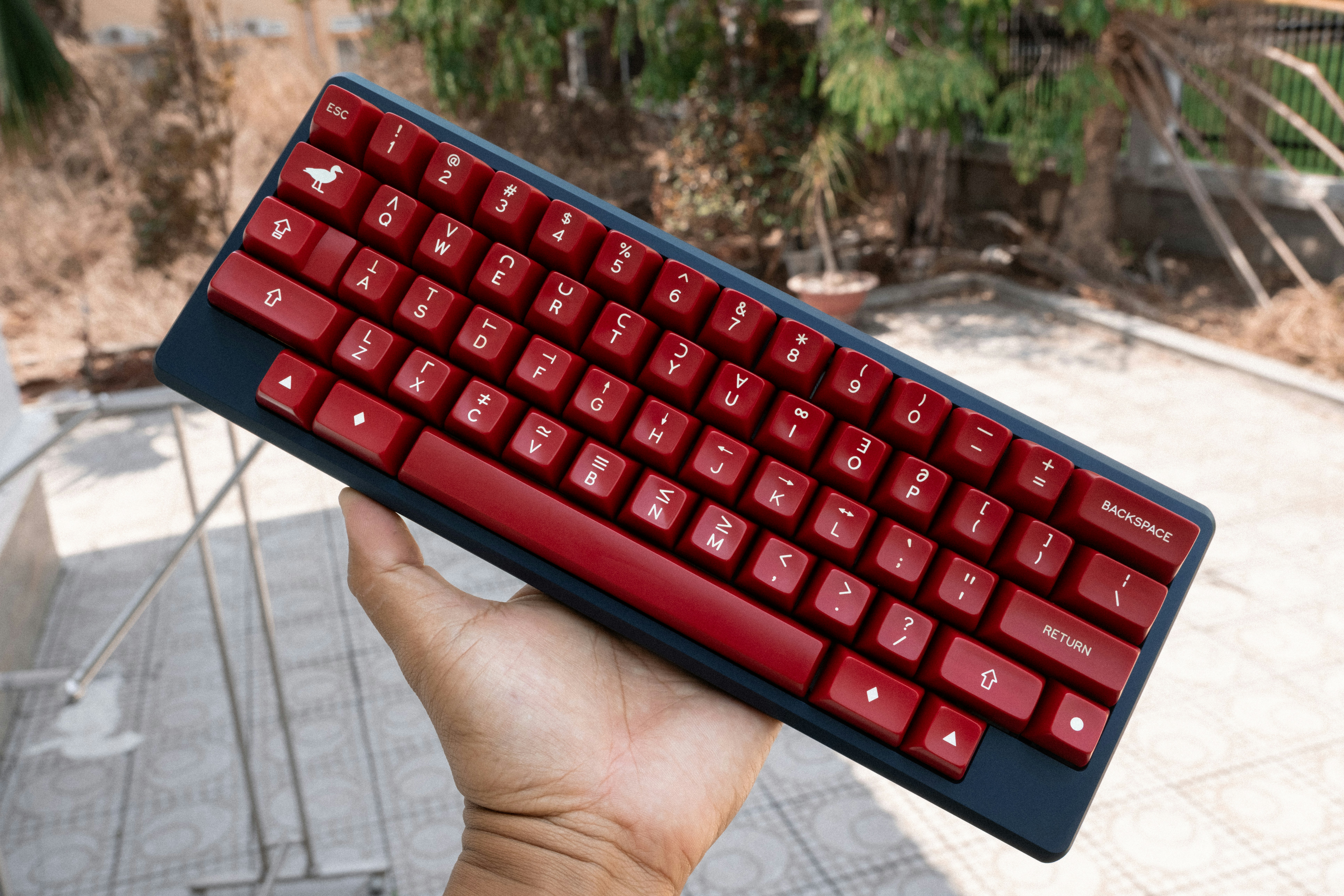 a person holding a red keyboard in their hand