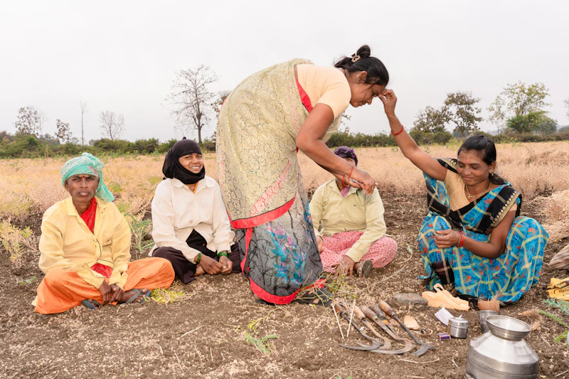 Women in saris talking together in a dry farm field