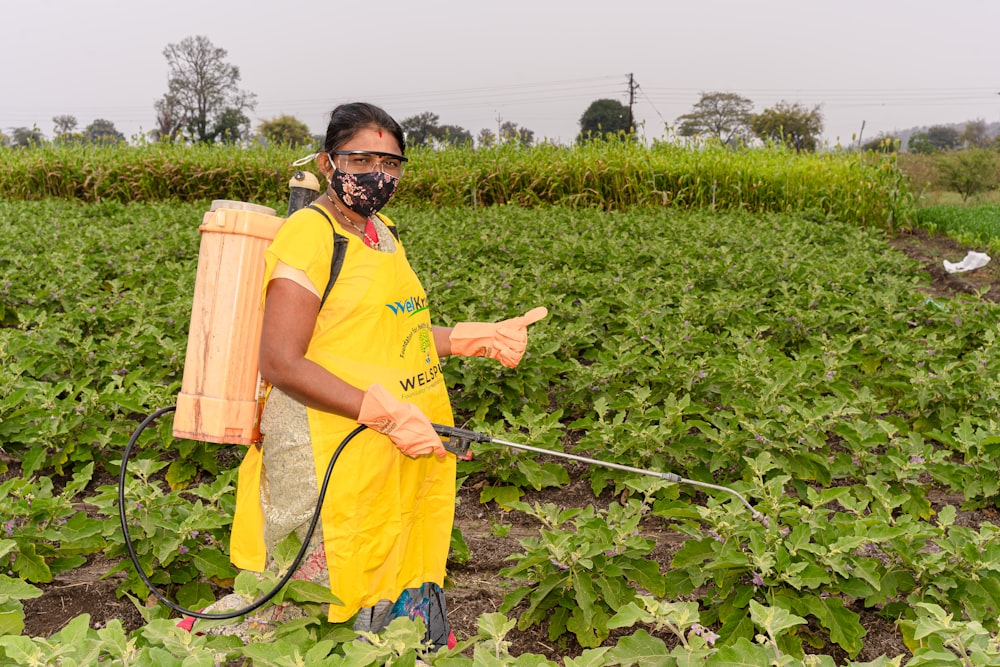 a person in a field with a sprayer