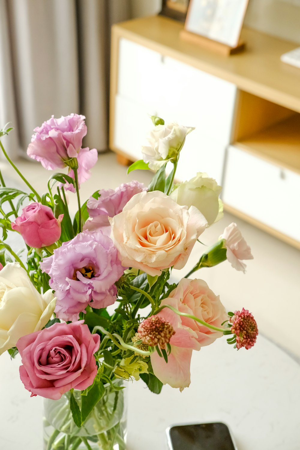 a vase filled with lots of different colored flowers