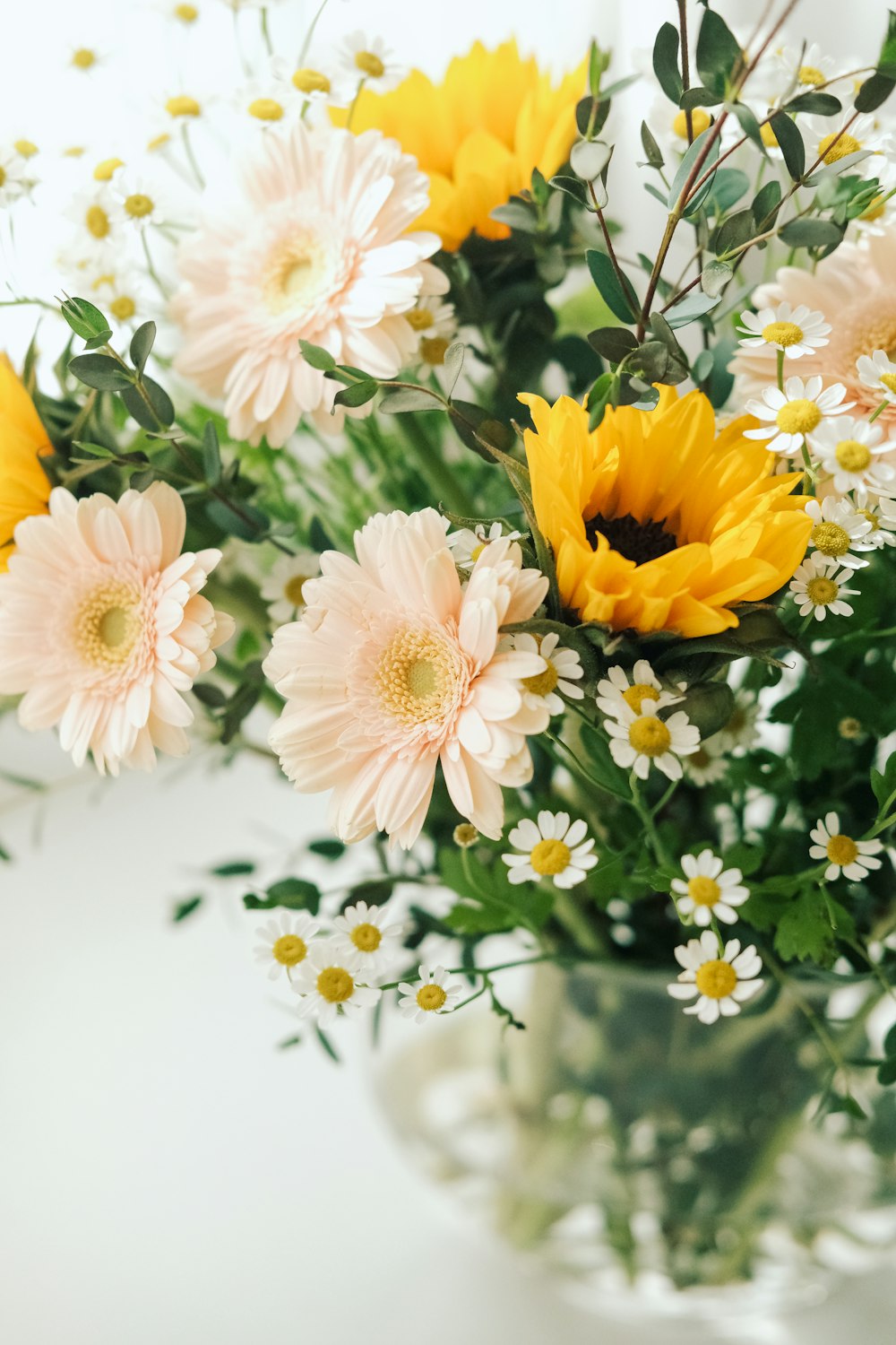 a vase filled with yellow and white flowers