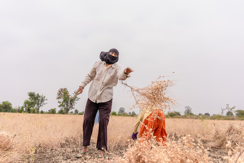 a man standing in a field of dry grass