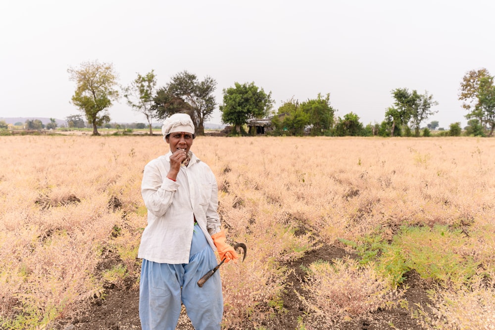 a man standing in a field holding a saw