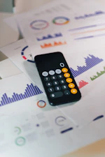 smartphone calculator app on financial report papers