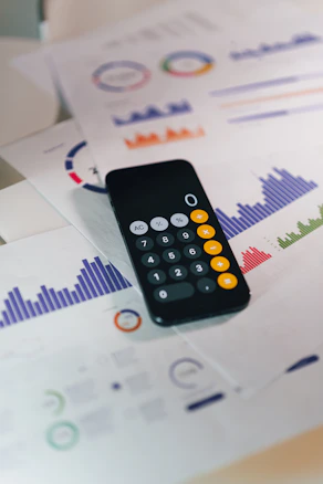 smartphone calculator app on financial report papers