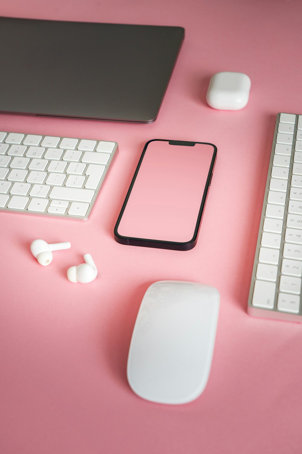 ein rosafarbener Schreibtisch mit Tastatur, Maus und Telefon