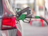Une pompe à essence est raccordée à une voiture dans une station-service.