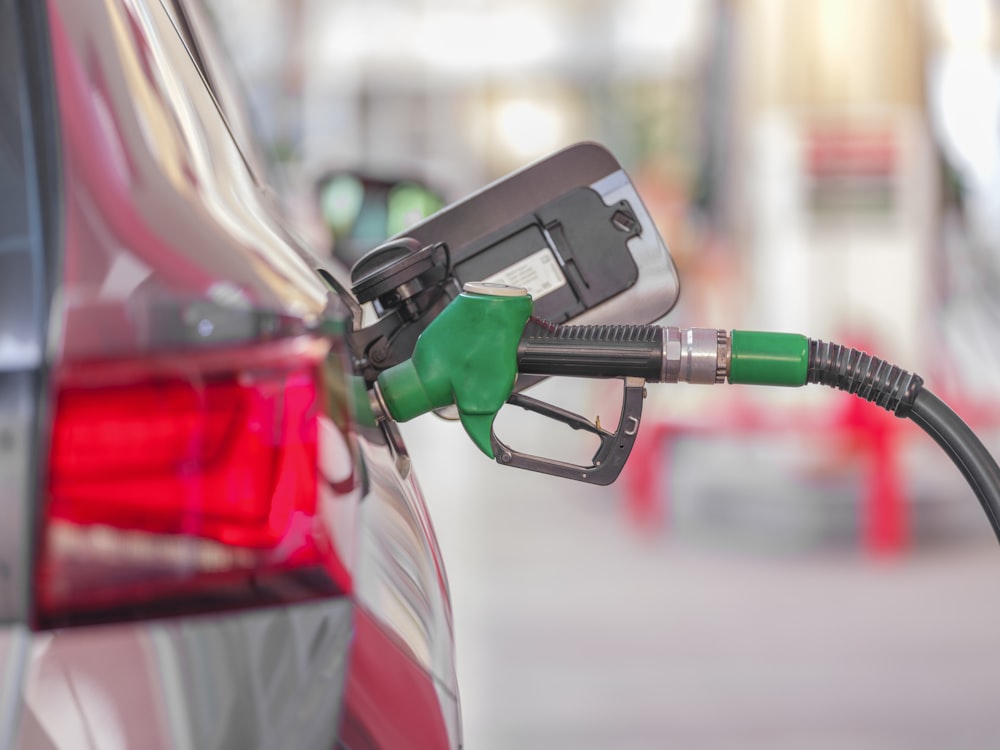 Uma bomba de gasolina é conectada a um carro em um posto de gasolina