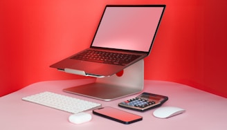 a laptop computer sitting on top of a desk next to a keyboard