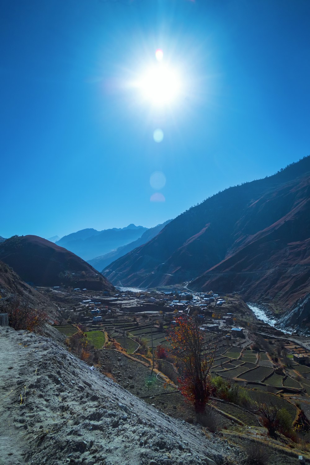 the sun shines brightly over a valley in the mountains