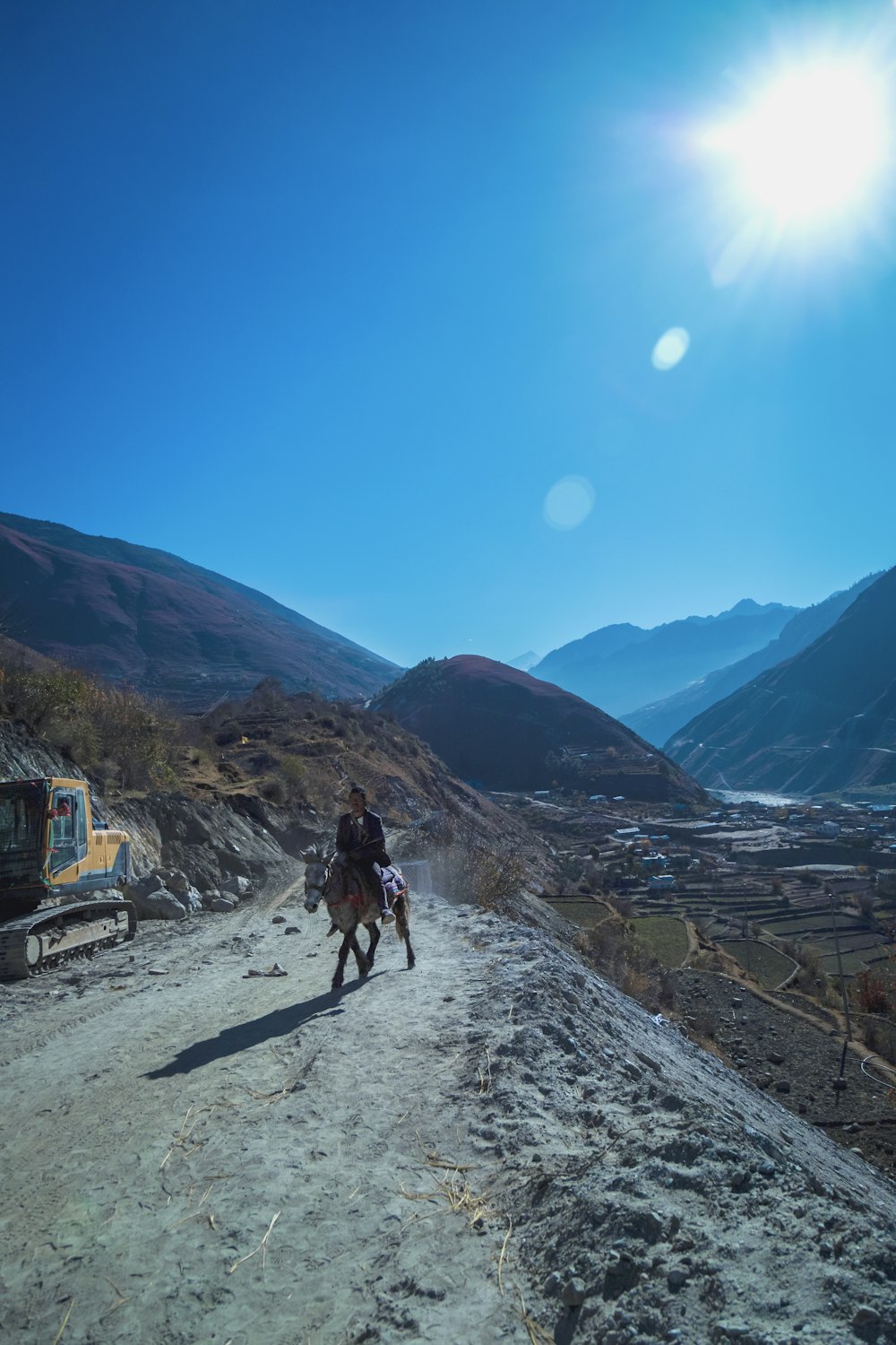 a man riding a horse down a dirt road