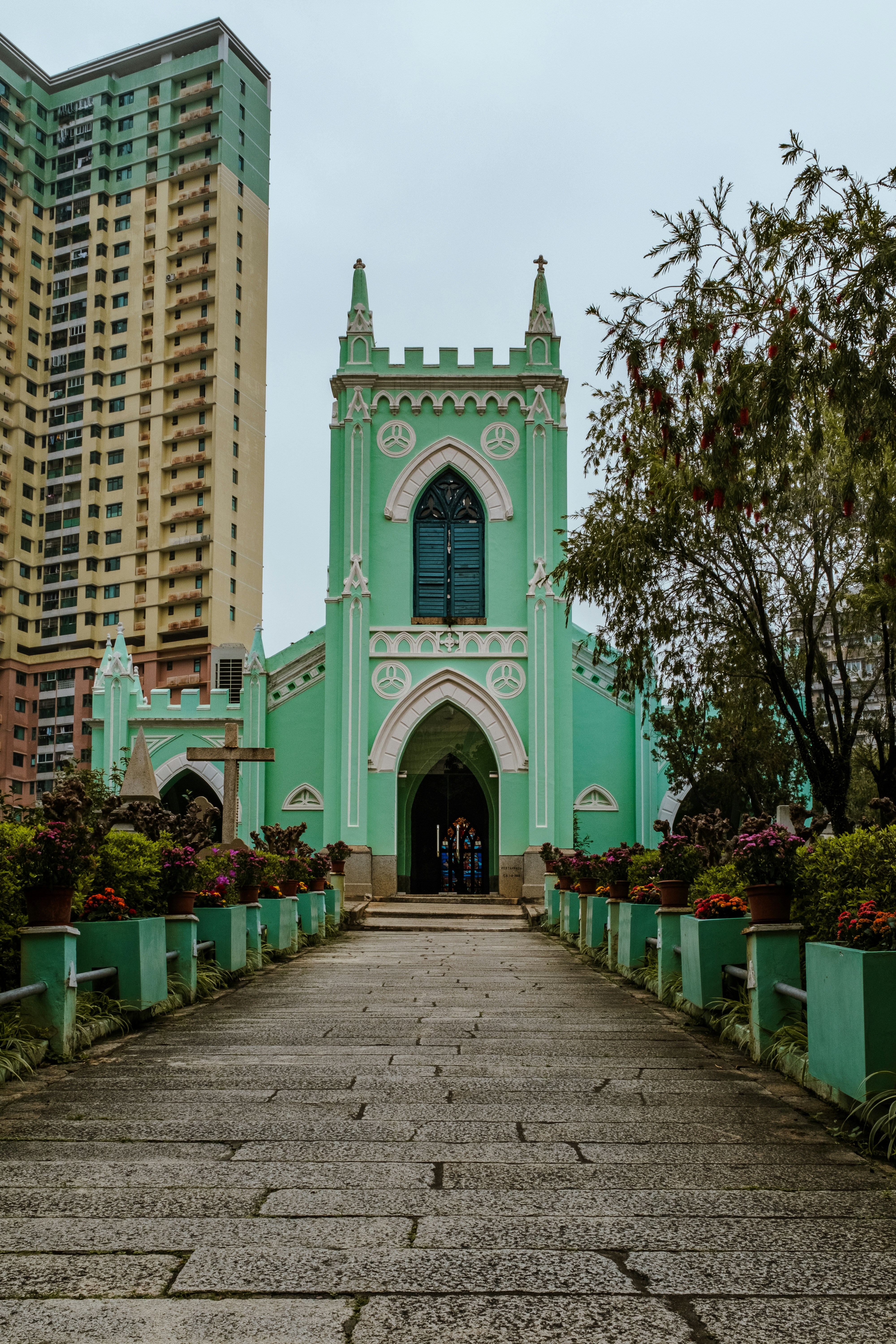 A large green church with a tall building in the background photo ...