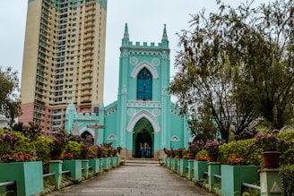 a blue church with a tall building in the background