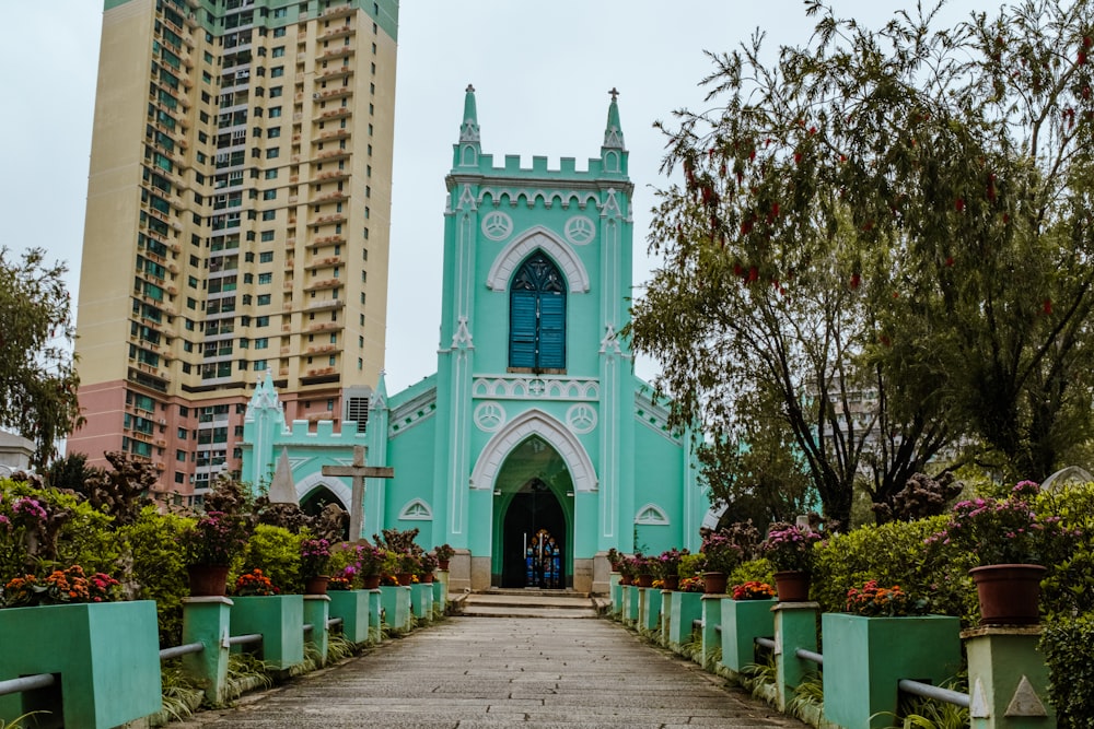 a blue church with a tall building in the background