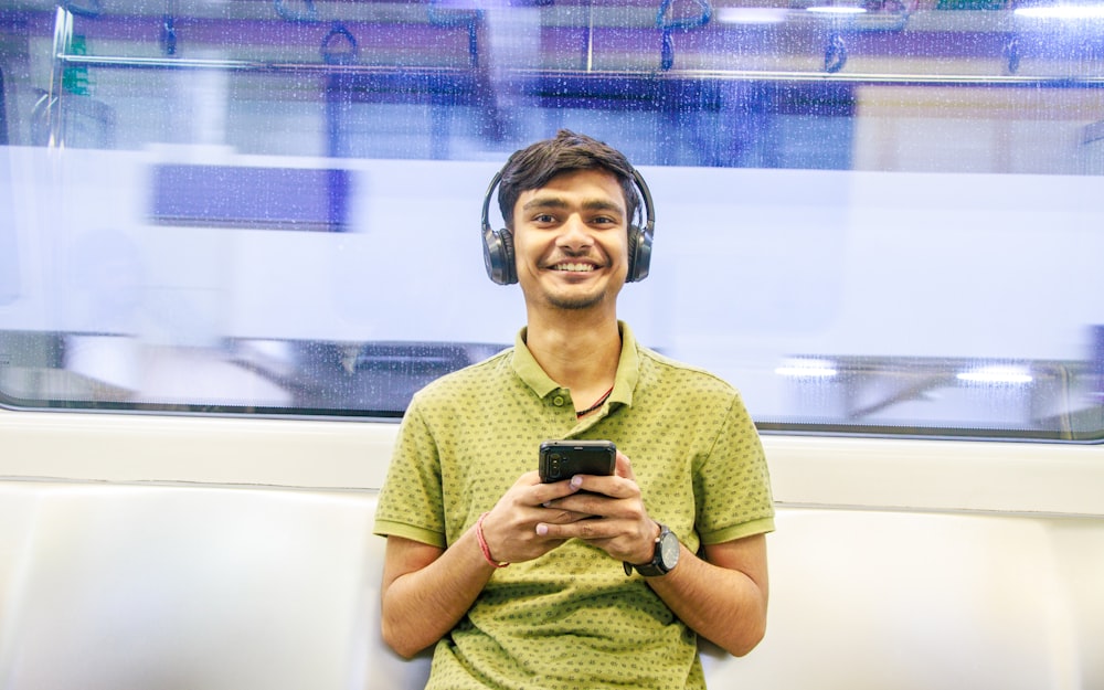 a man wearing headphones is looking at his cell phone