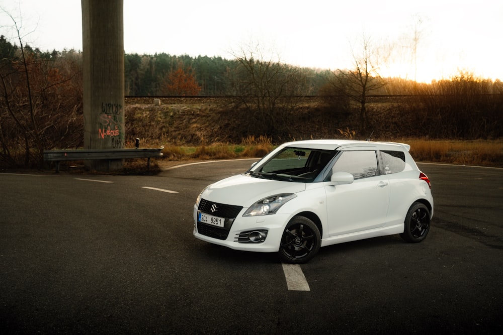 a small white car parked in a parking lot