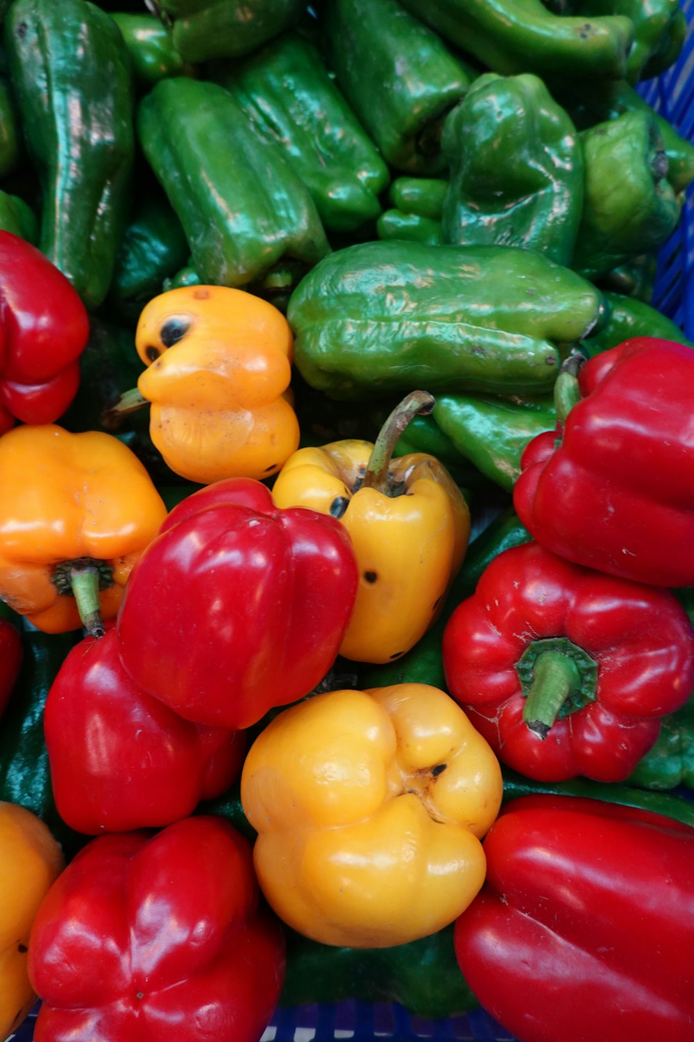 a pile of red, yellow and green peppers