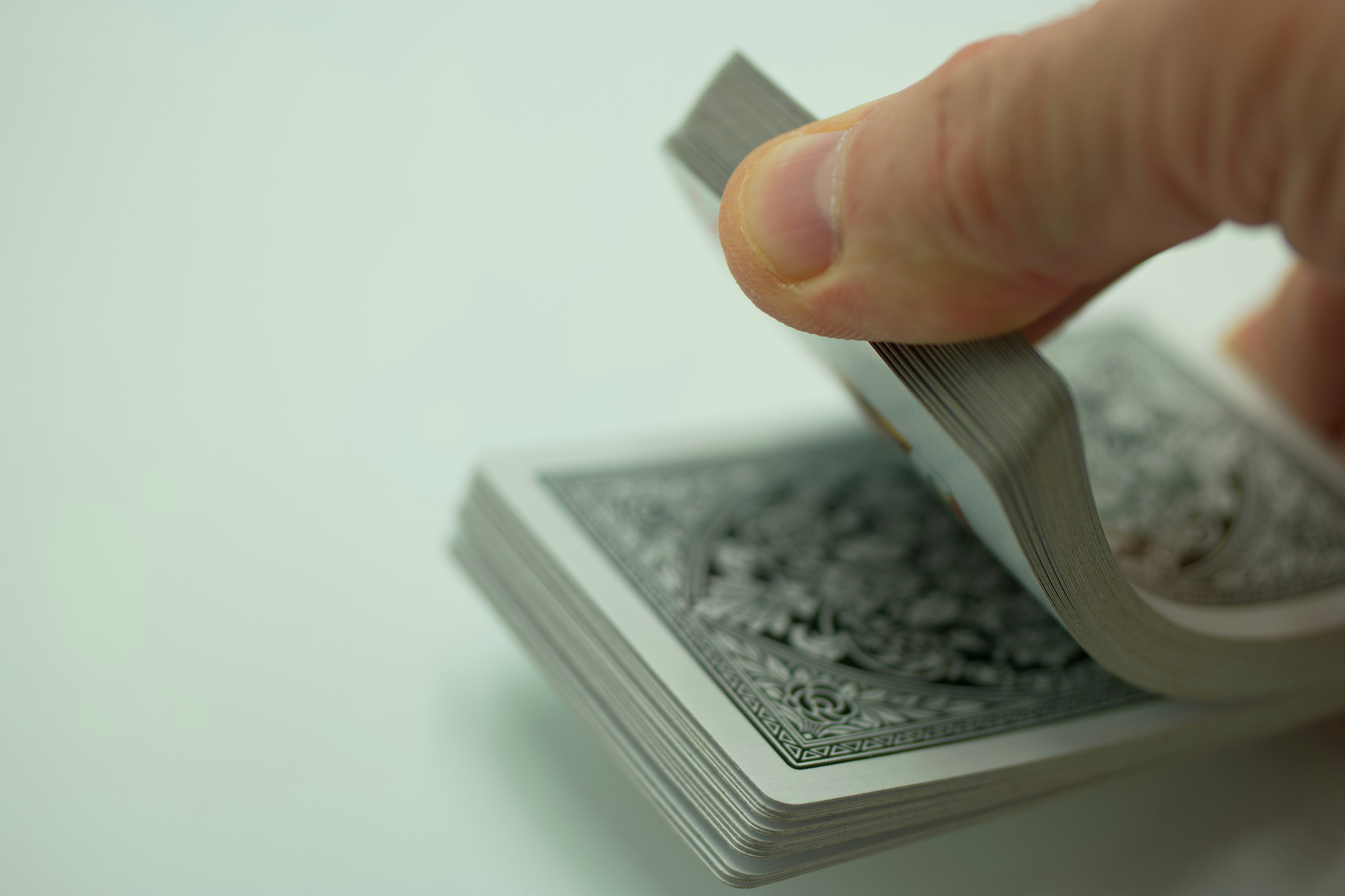 a hand holding a playing card with a white background