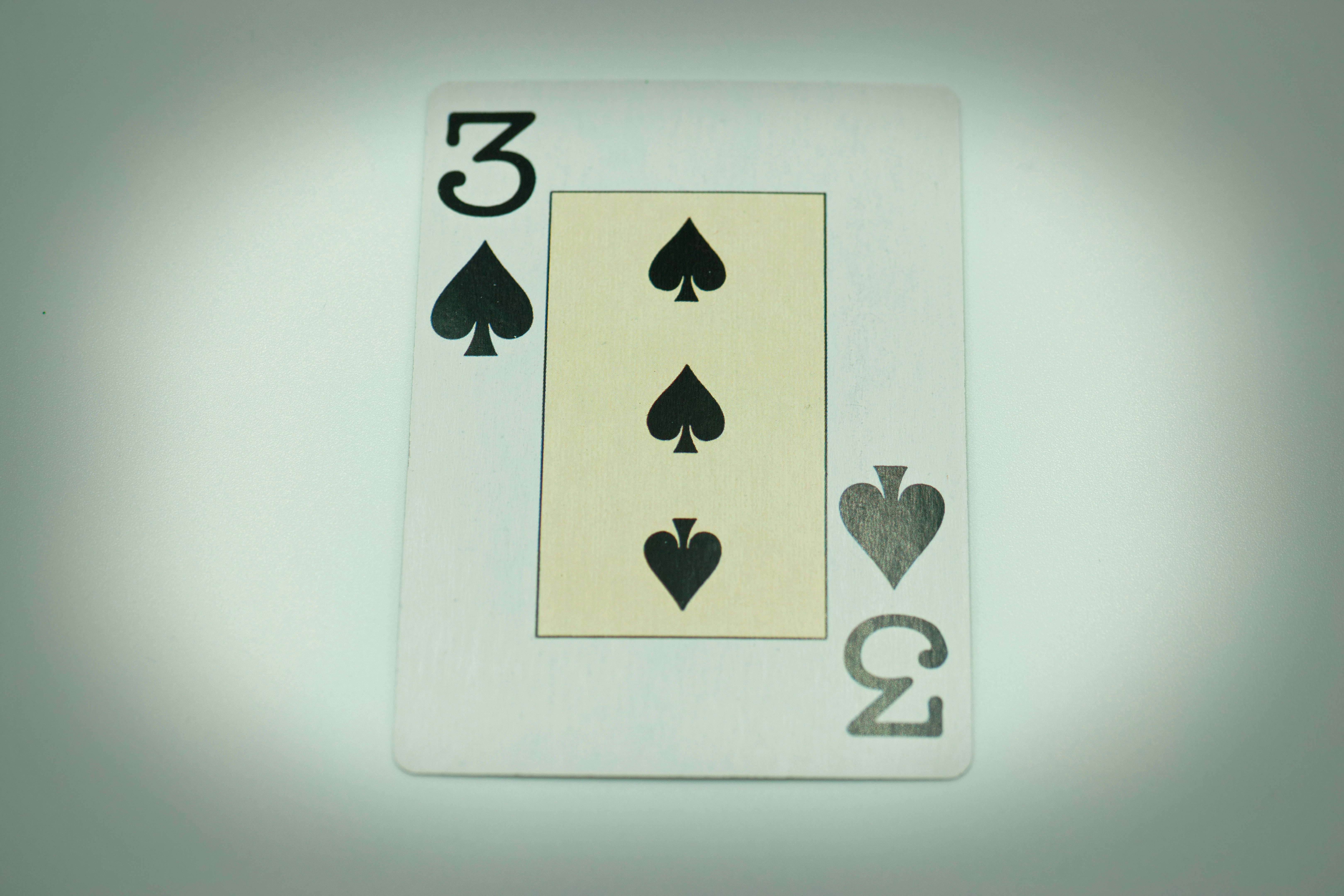 a four of spades playing card on a table