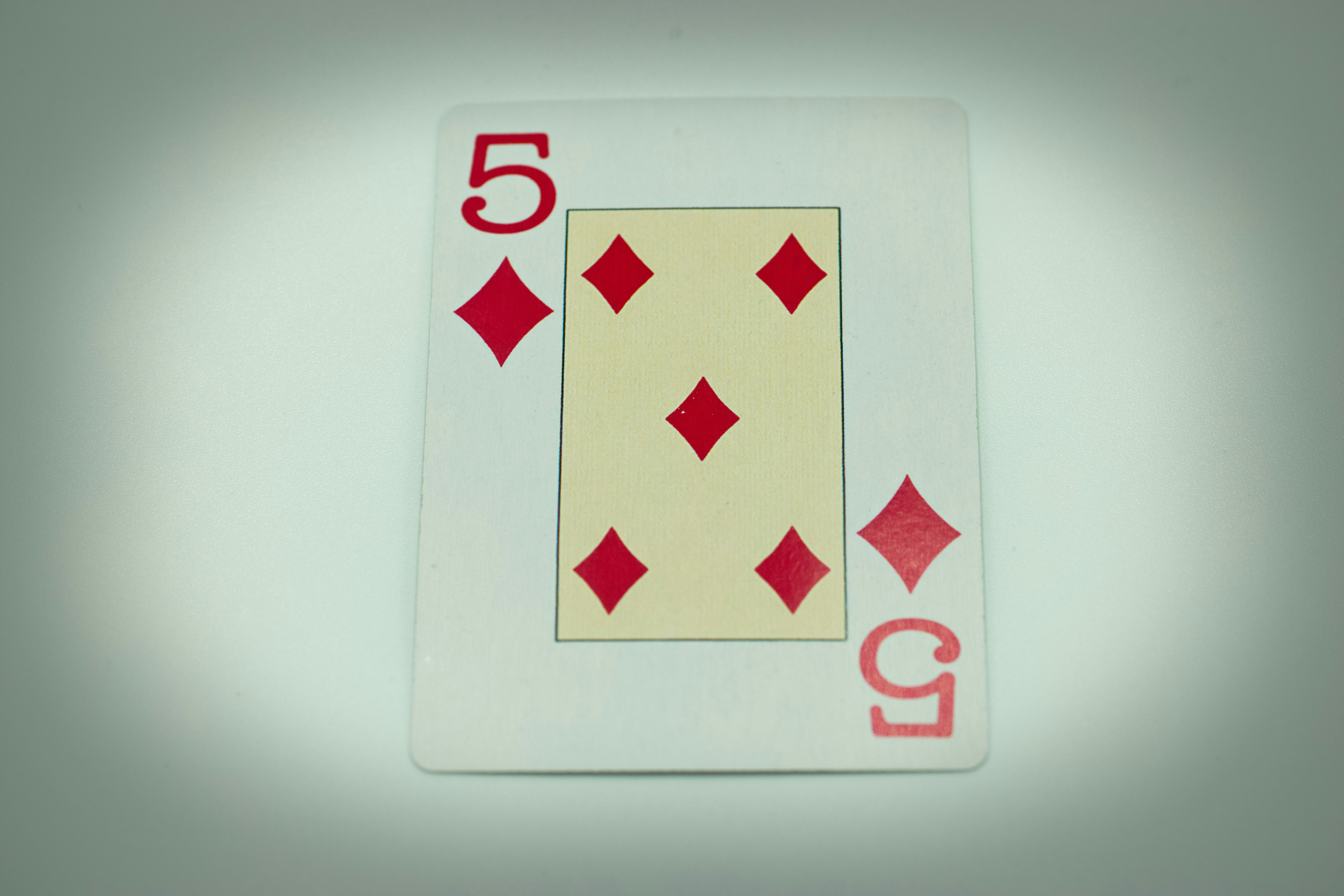 a white playing card with red diamonds on it