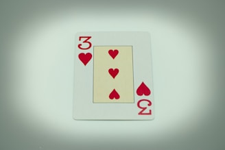 a four of hearts playing card on a table