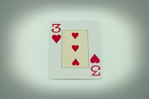 a four of hearts playing card on a table