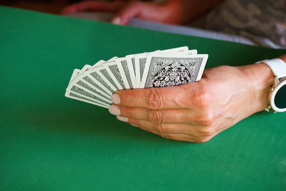 a person holding a stack of playing cards