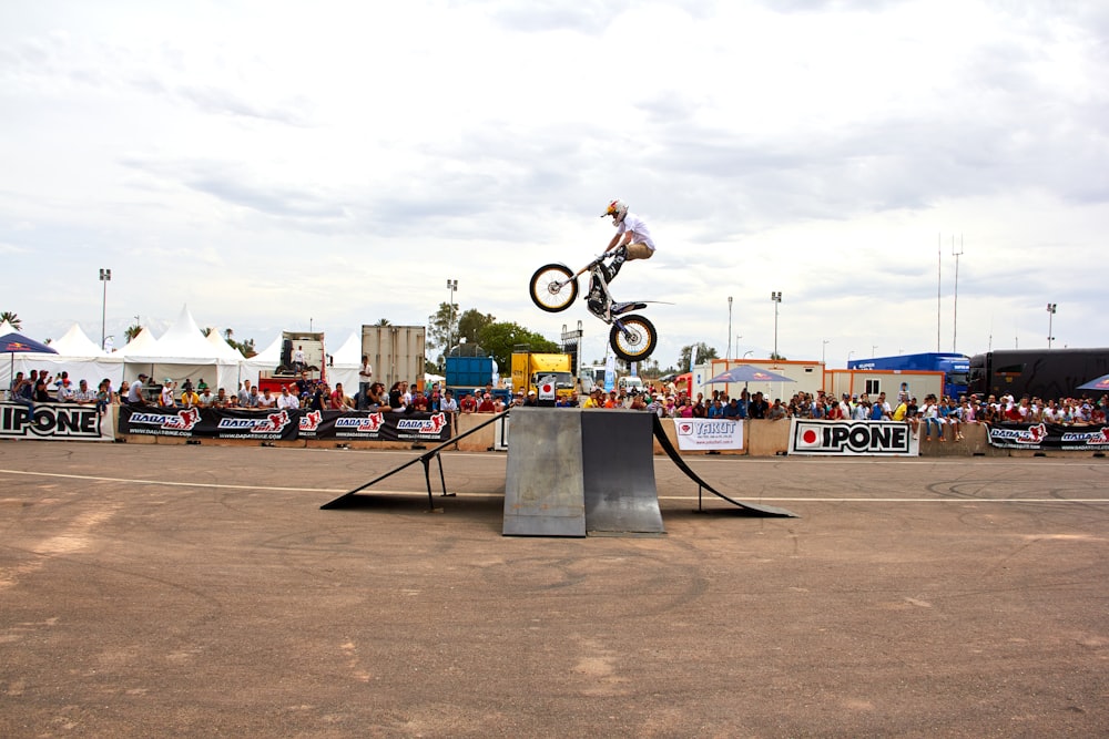 a person on a bike jumping over a ramp