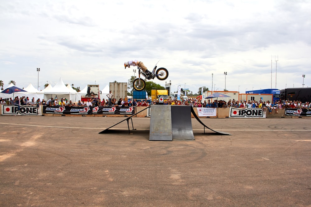 a person on a motorcycle jumping over a ramp