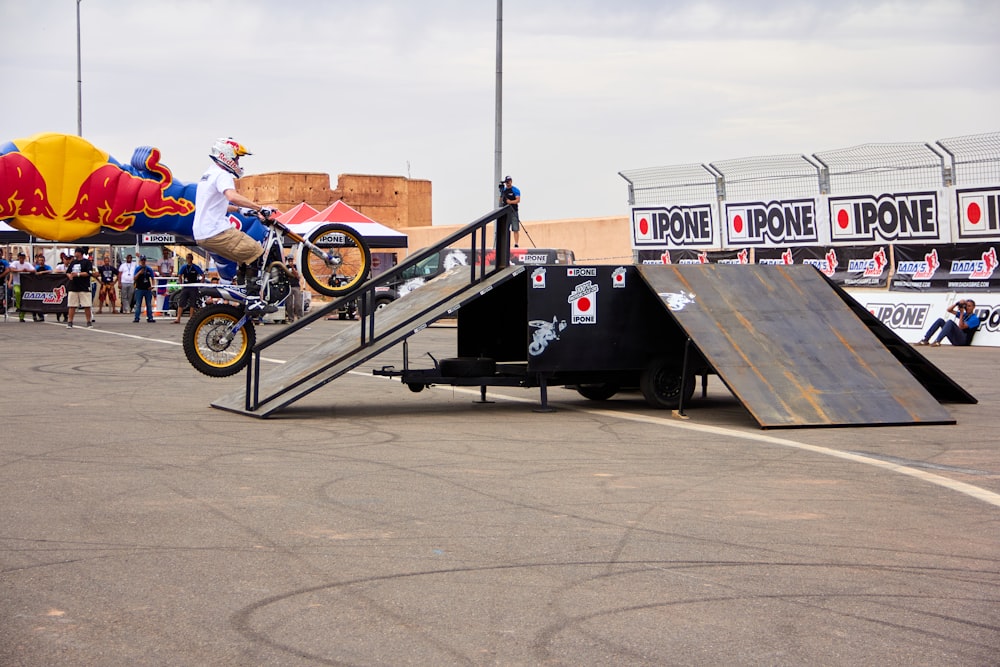 a man riding a motorcycle up the side of a ramp