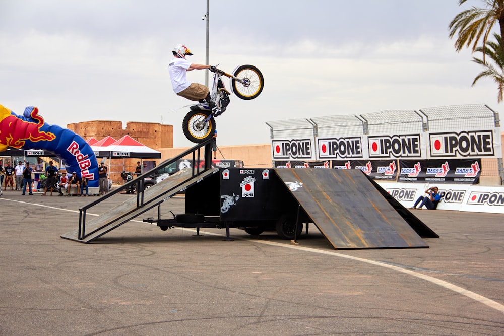 a man riding a bike up the side of a ramp