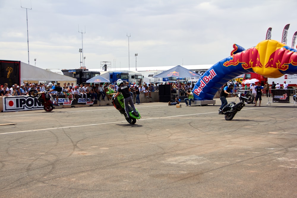 two motorcyclists racing on a race track in front of a crowd