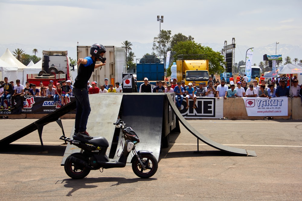 a man riding a scooter next to a ramp