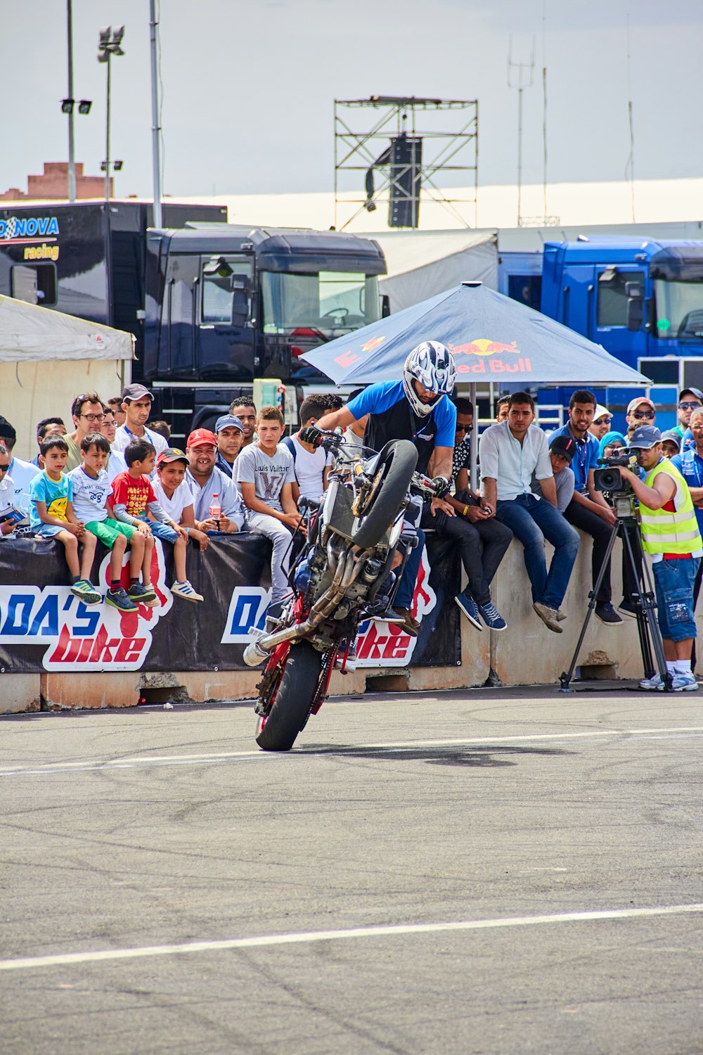 a person on a motorcycle doing a trick in front of a crowd