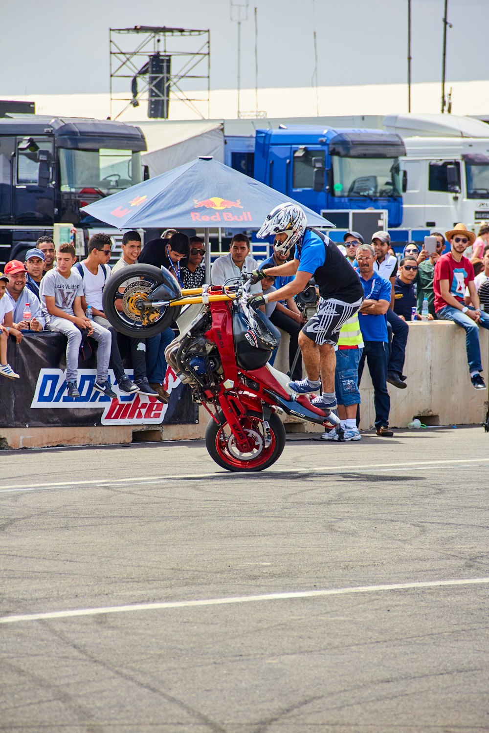 a person on a motorcycle doing a trick in front of a crowd