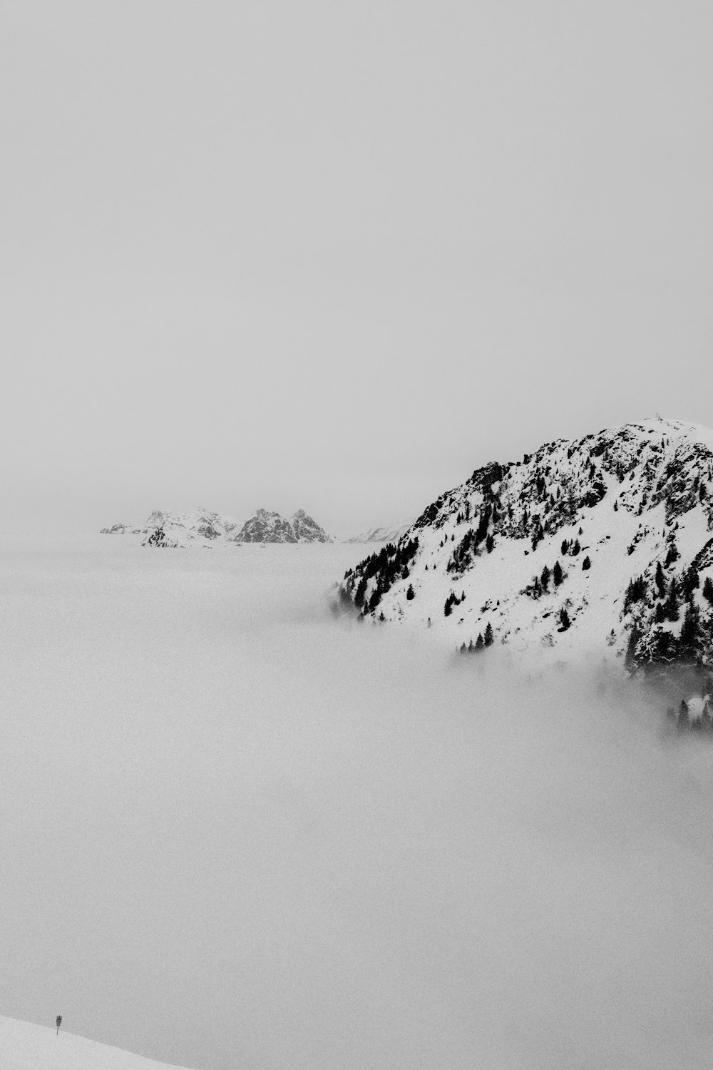 a black and white photo of a snow covered mountain