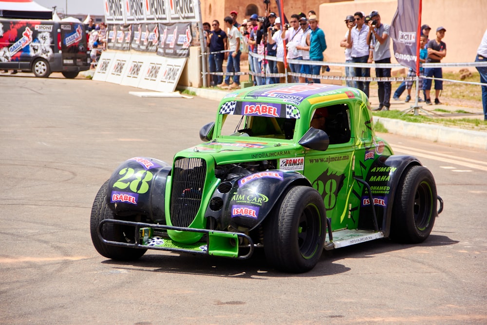 a green and black truck driving down a street