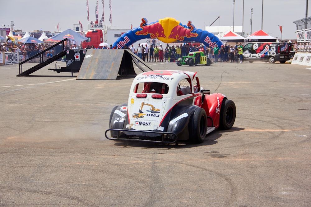 a race car driving around a track with people watching