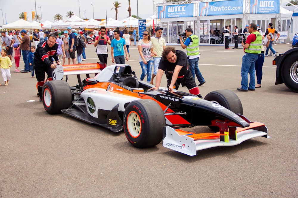 a man working on a race car in a parking lot