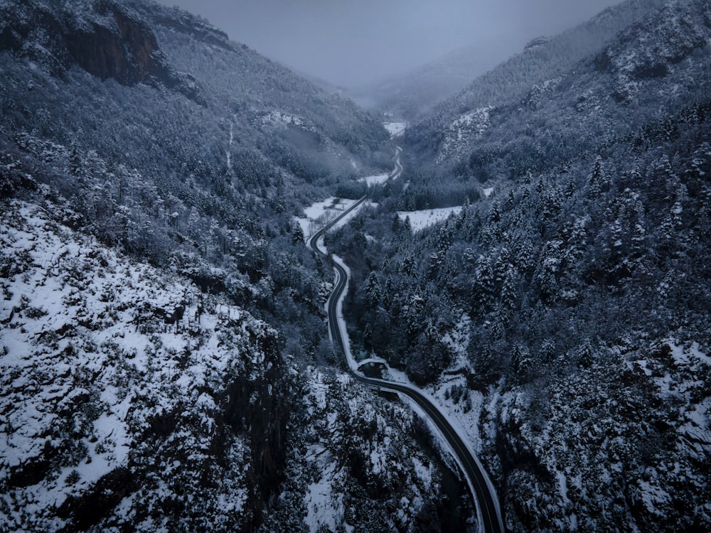 a winding road surrounded by snow covered mountains