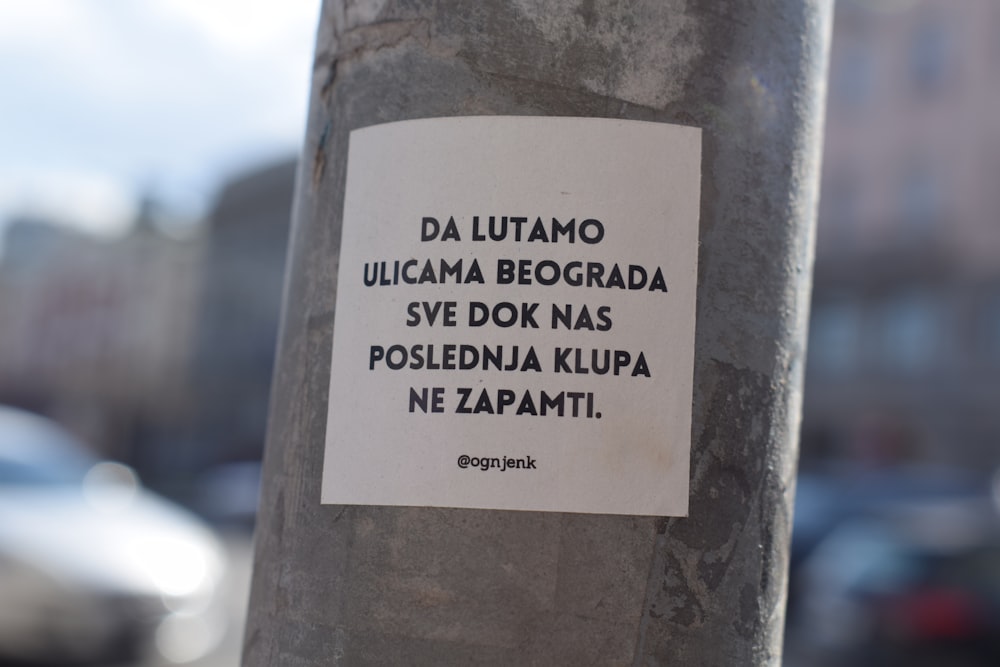 a sticker on a pole on a city street