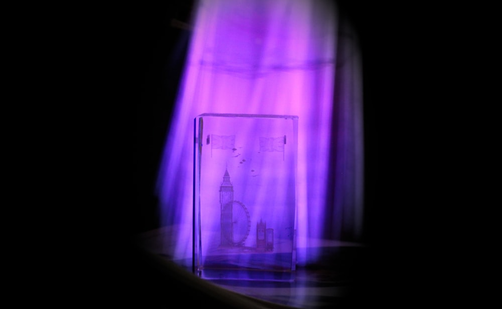 a purple light shines on a glass block
