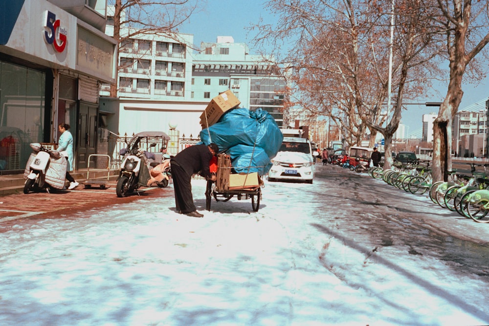 a person pushing a cart down a snowy street