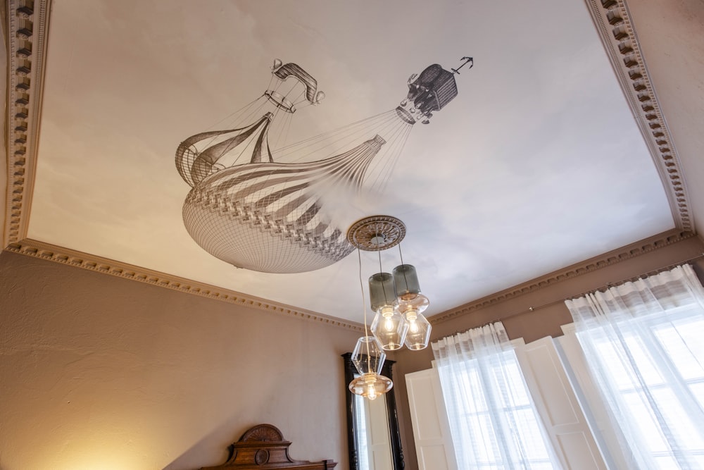 a bedroom with a chandelier and a painting on the ceiling