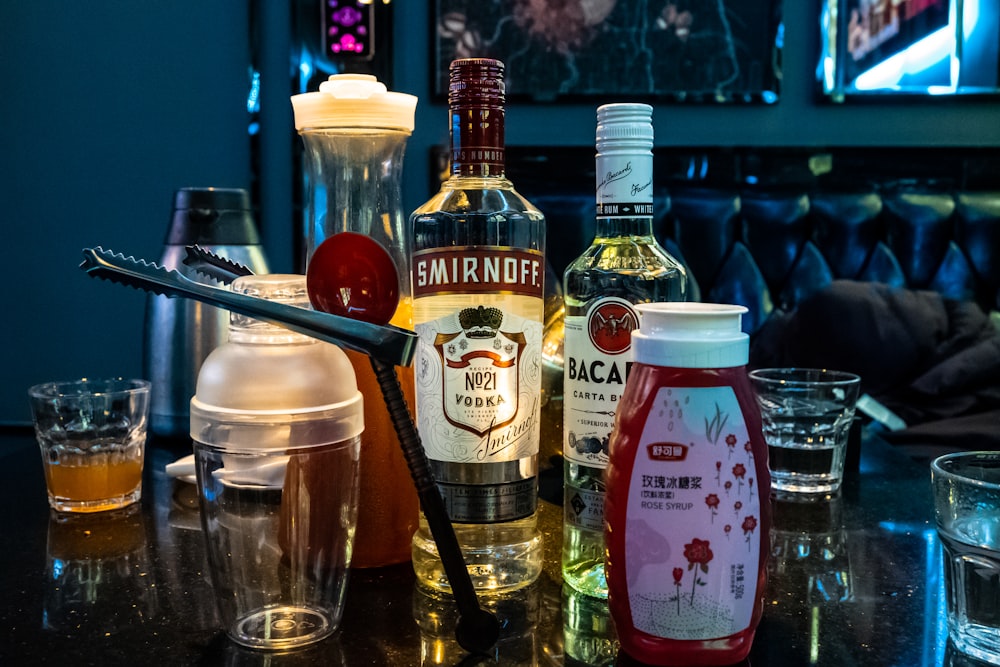 a table topped with bottles of alcohol and glasses