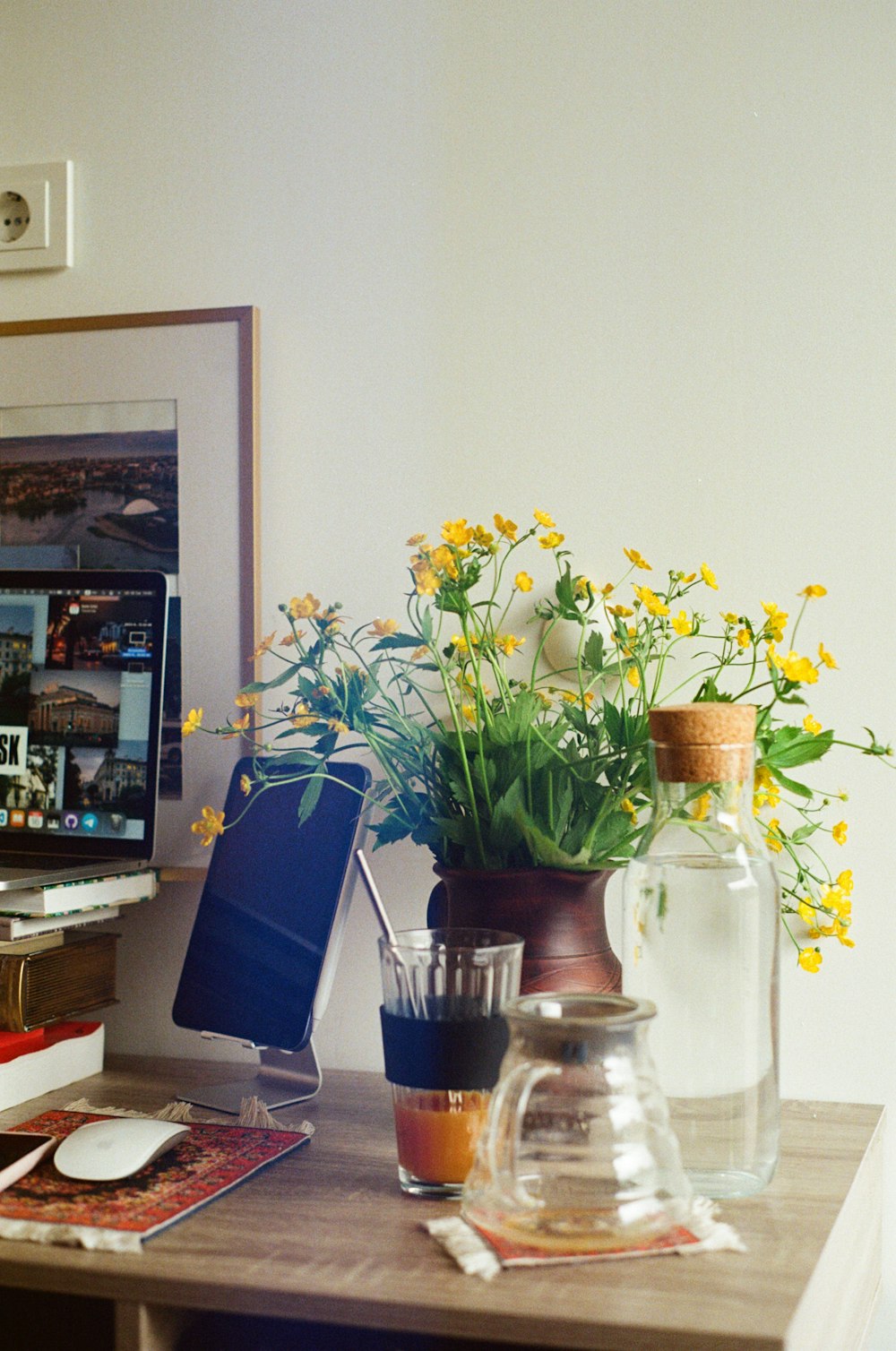a desk with a vase of flowers on it