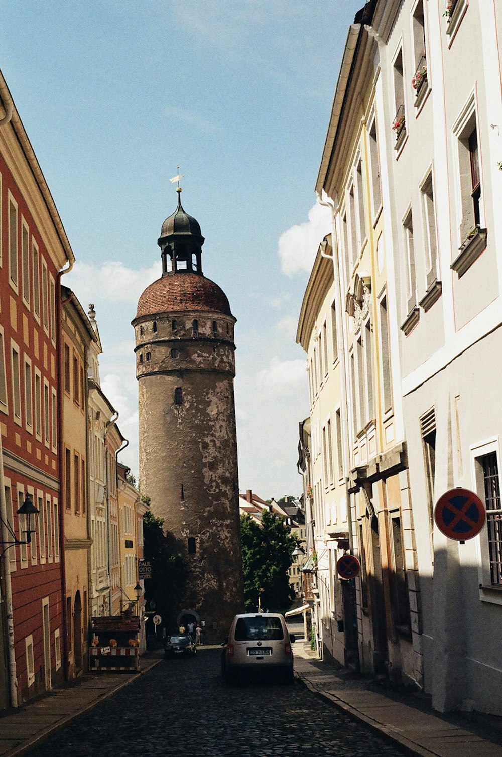 a car is parked in front of a tall tower